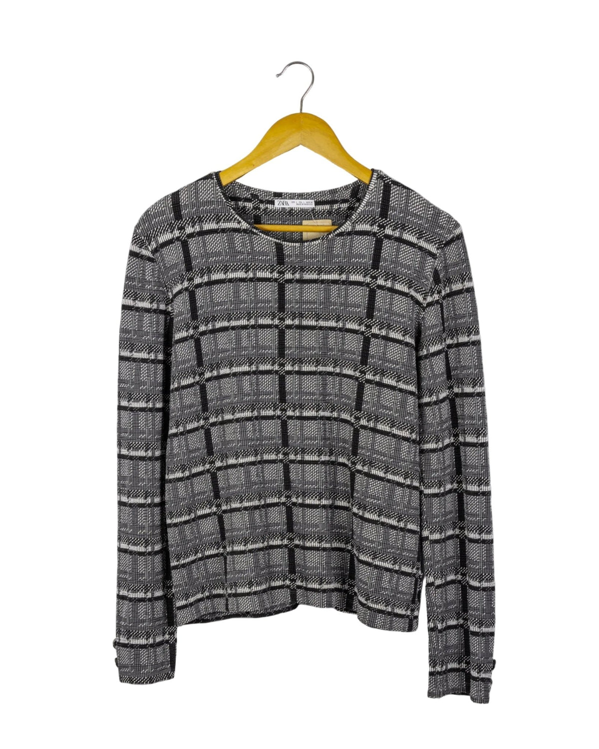 Polo manga larga Zara, de tela acanalada de cuadros grises y negros, con botones plateados en los puños