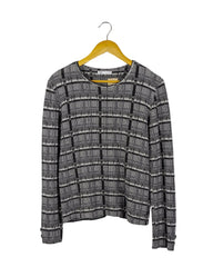 Polo manga larga Zara, de tela acanalada de cuadros grises y negros, con botones plateados en los puños