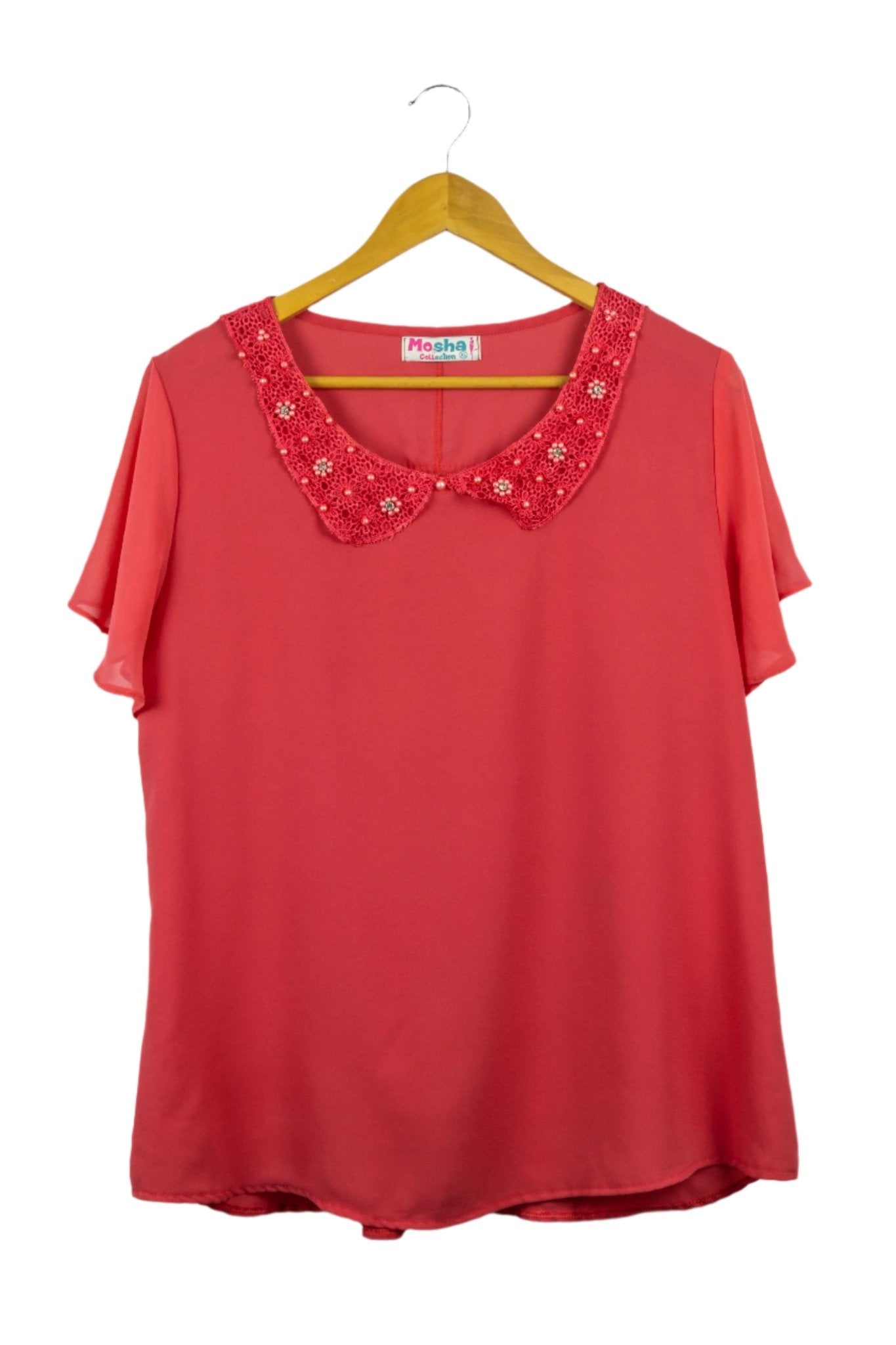 Blusa fucsia de gasa, cuello camisero redondeado con perlitas fucsias y manga corta con vuelos.