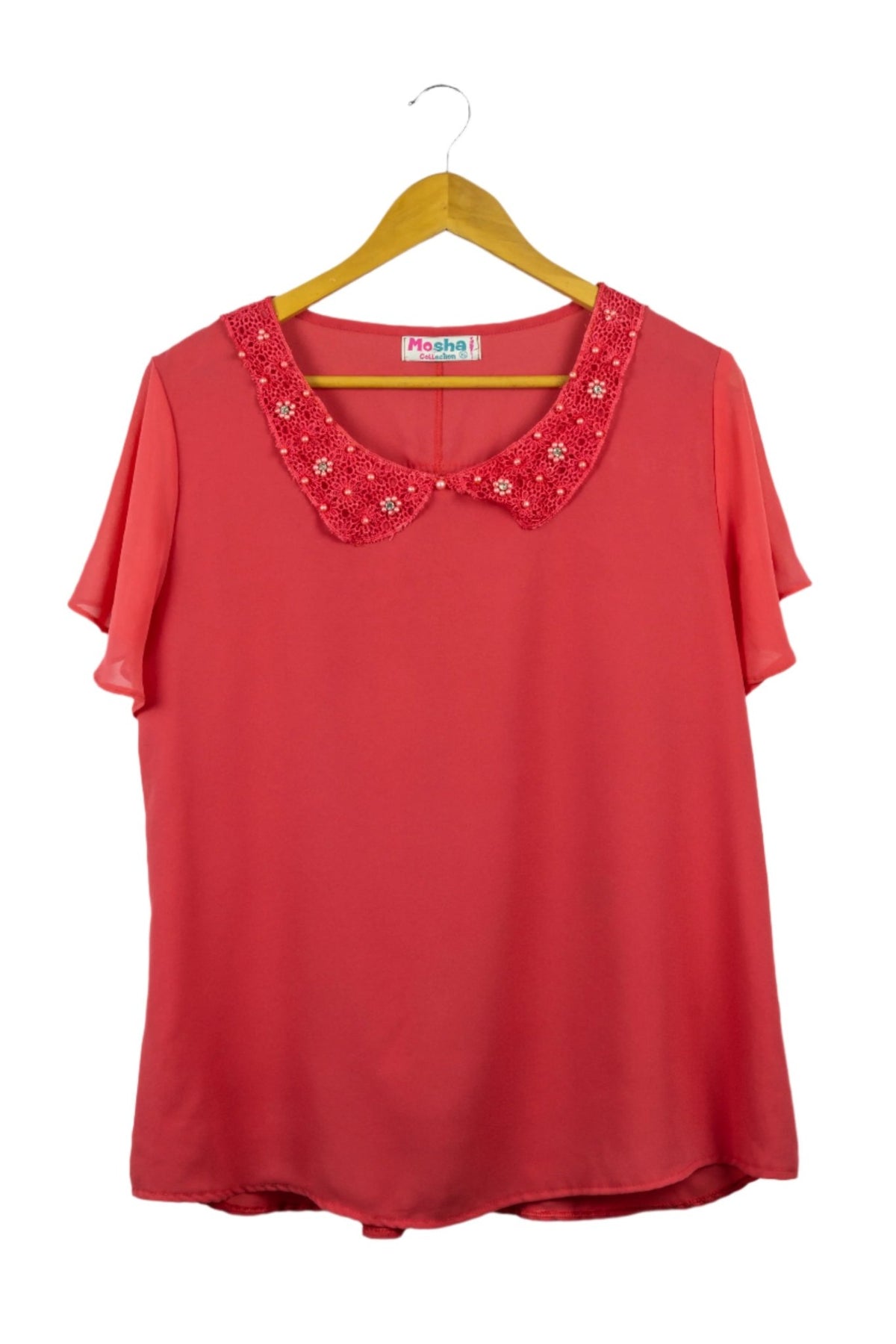 Blusa fucsia de gasa, cuello camisero redondeado con perlitas fucsias y manga corta con vuelos.