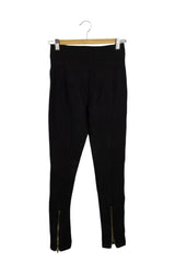 Pantalón Basement negro stretch con bolsillos dorados en frente y cierres en tobillos