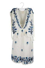 Polivestido Zara Trafaluc blanco con flores bordadas azules, manga cero y cuello V, vuelos bajo el busto y tiras colgando de hombros