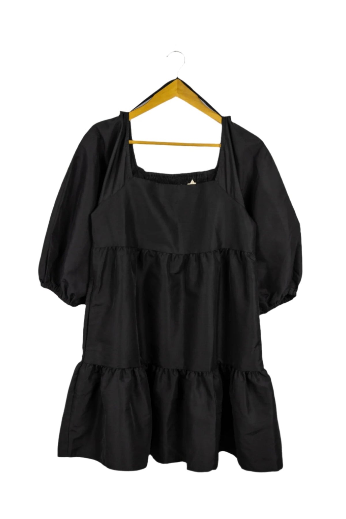 Vestido negro, mangas abullonadas, cuello cuadrado.