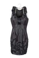 Vestido Just Taylor plomo corto satinado manga cero, cuello en V con vuelos a los lados y pinzas en cintura, adorno de cinta plizada en diseño de espirales en falda.