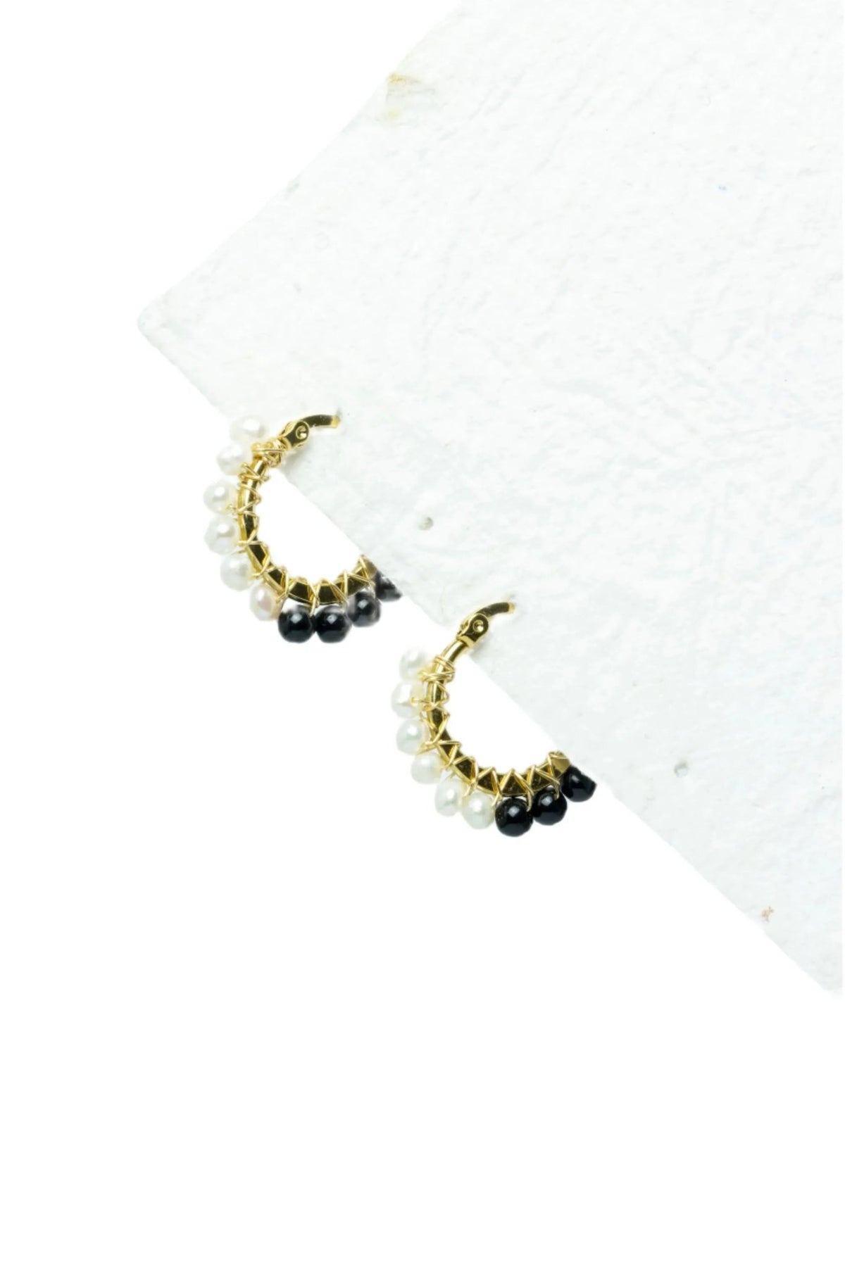 Argollas livianas colgantes de acero inox, baño oro 24K y cuentas checas blancas y negras.